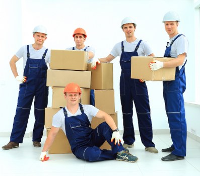 Removal team carrying household items from a Wembley Park apartment building
