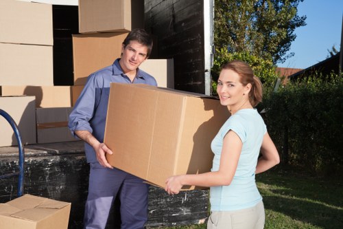 Removal crew carrying boxed goods into a property